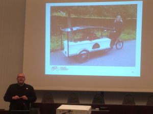 "In Dänemark radeln wir von der Wiege bis zur Bahre", sagt Bondam und zeigt eine radfahrende Bestatterin 