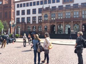 Passanten verfolgen neugierig den Film-Dreh im Sonnenschein