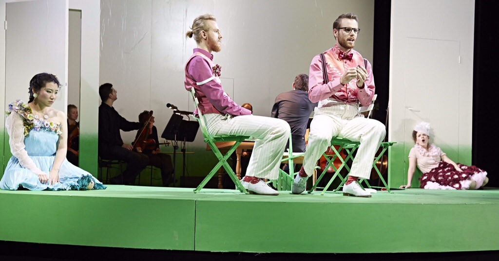 Minimalistisches Bühnenbild: Grüne Bühne, halbrund, weiße Wände, im Hintergrund die Musiker, vorne die Sänger (v.l.): Lisetta (Saem You), Armindo (Jonas Boy), Eurillo (Nikolaus Pfannkuch), Clori (Ruth Katharina Peeck) Foto: Karl-Bernd Karwasz