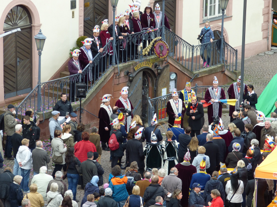 Die Dachorganisation Wiesbadener Karneval 1950 e.V. (DACHO) hat heute um 11.11 Uhr vor dem Rathaus feierlich die Fahne gehisst. Mit dabei: OB Sven Gerich (SPD, M. mit rotem Mikro), der DACHO-Vorstand, das Prinzenpaar Harald I. (mit langer Feder an der Narrenkappe) und Jasmine I. und viele Neugierige. Foto: Sabine Voß/Stadt Wiesbaden